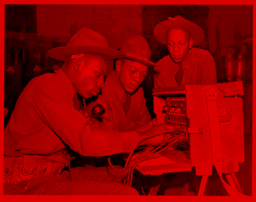 3 military men working on a portable phone switchboard